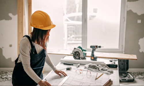 Contractor looking at blueprints surrounded by power tools